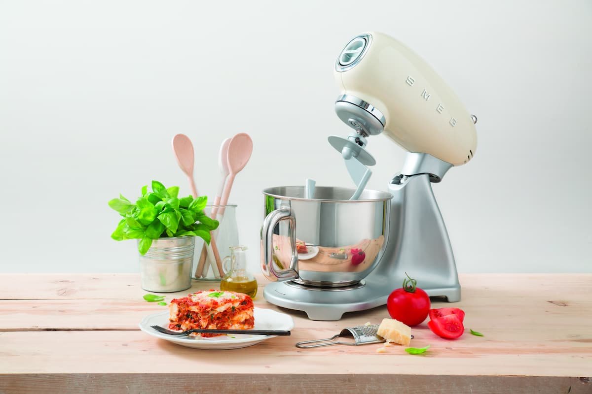 batedeira retro smeg ao lado de alguns ingredientes em cima da bancada